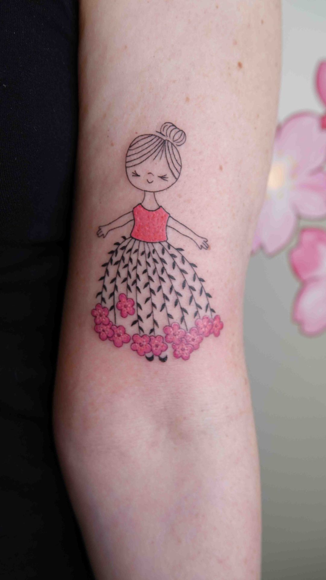 Meisje in een tutu met roze bloemen, in fijne lijnen op een bovenarm