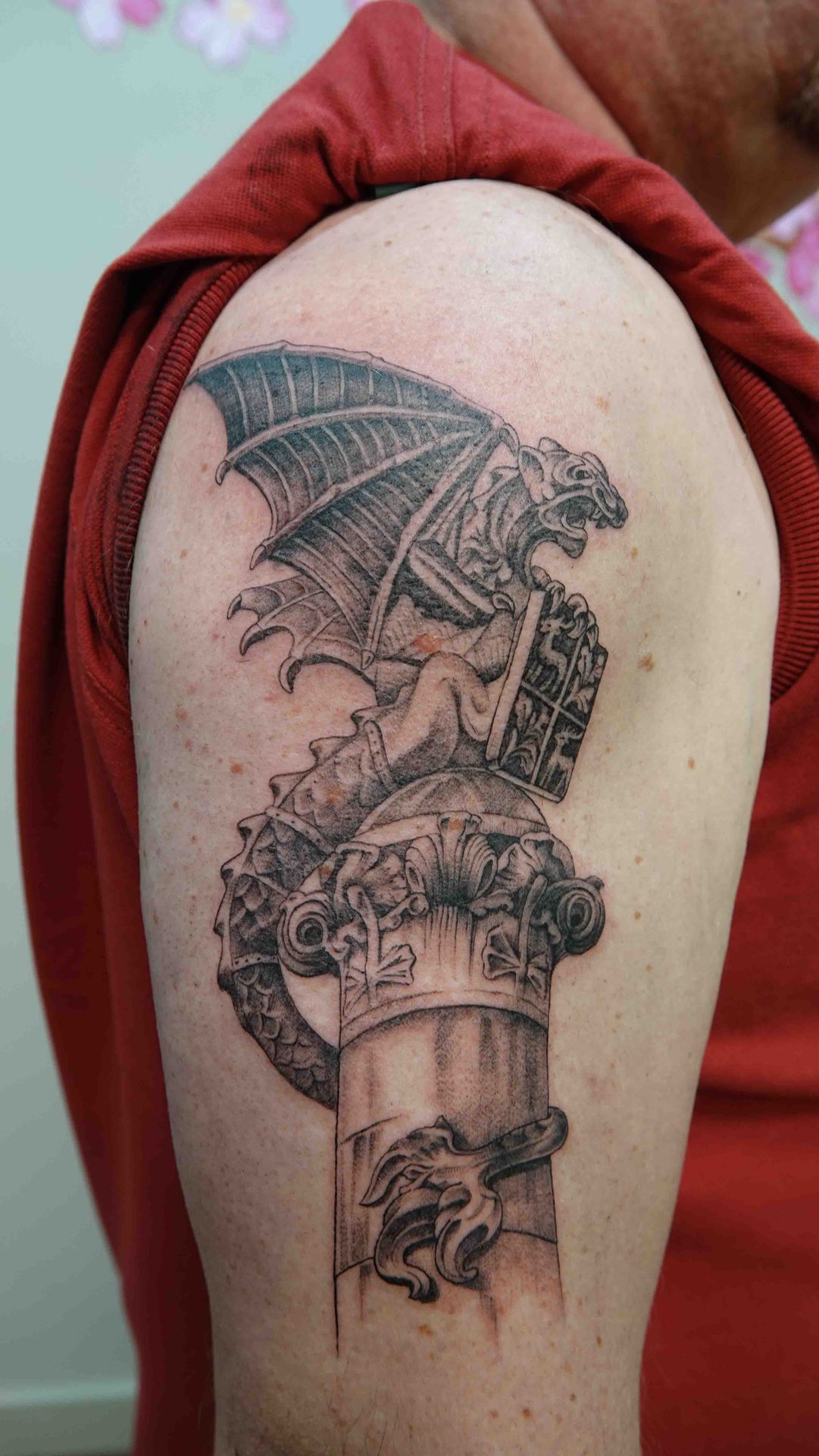 Gargouille op een stenen zuil, getatoeëerd op een bovenarm