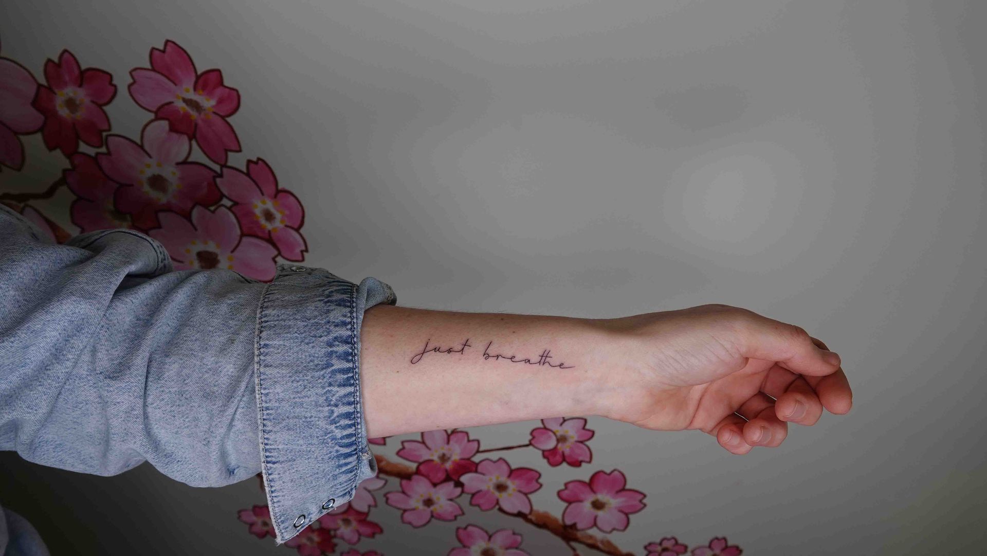 De woorden just breathe in dun handschrift op een onderarm