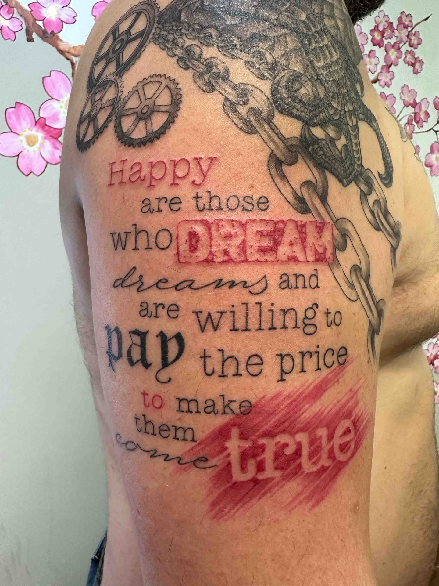 Schouderstuk in trash polka-stijl met tandwielen, kettingen en de tekst Happy are those who dream dreams and are willing to pay the price to make them come true