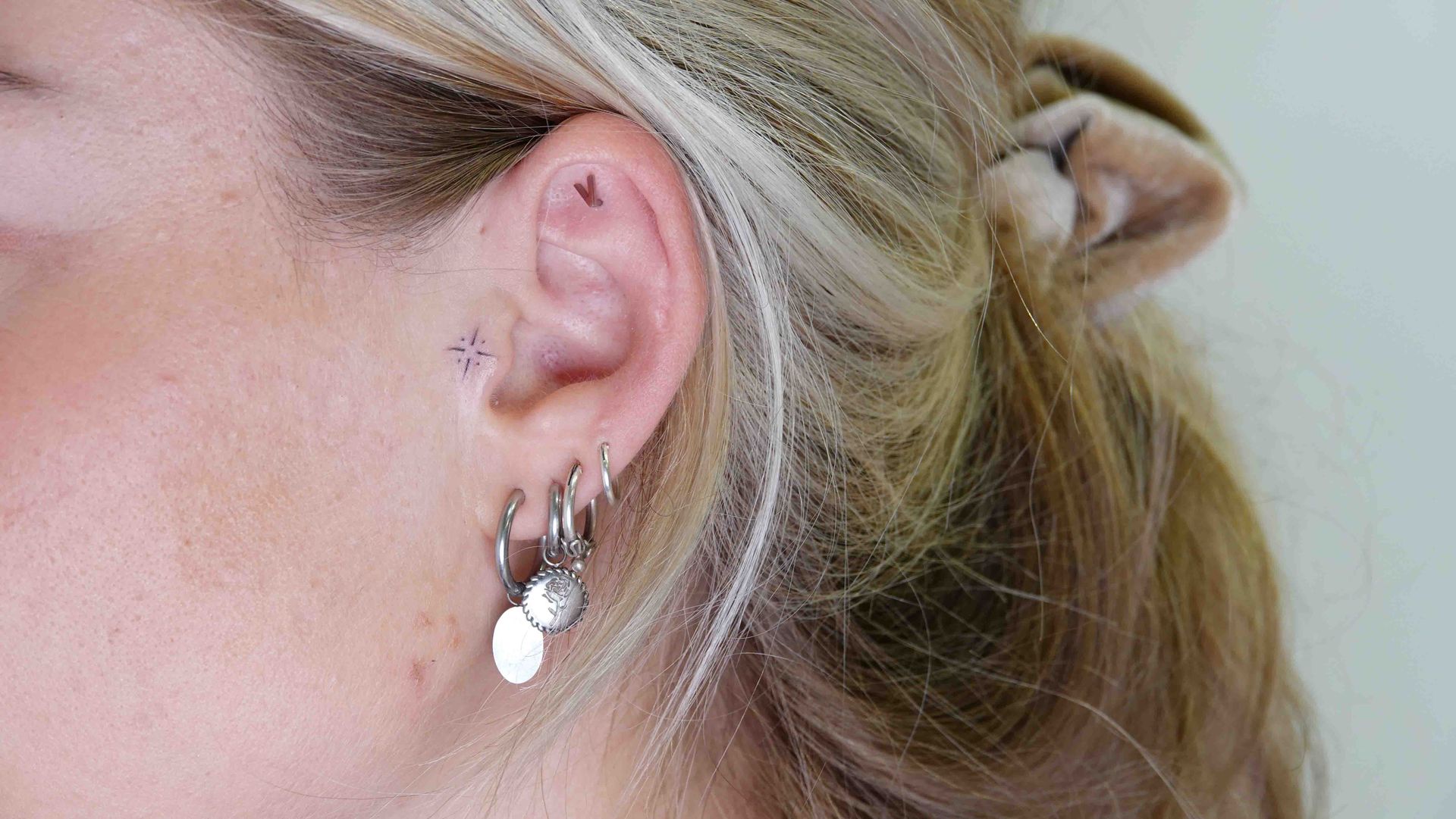 Oor met meerdere piercings in de lel en de helix