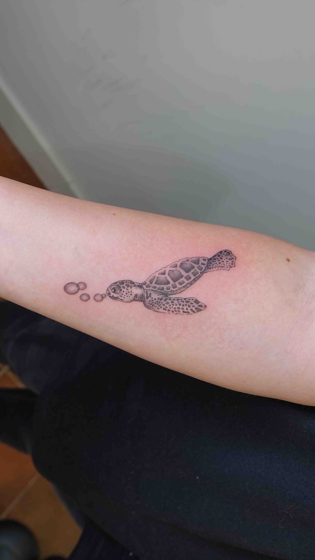 Zeeschildpad met luchtbelletjes op een onderarm