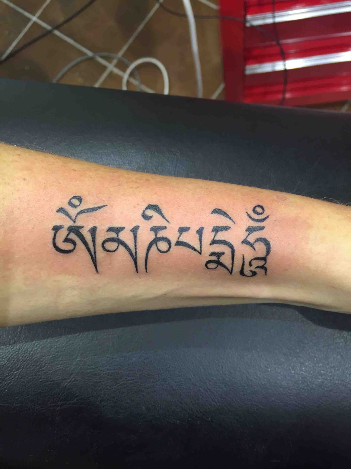 Tibetaanse tekst getatoeëerd op een onderarm