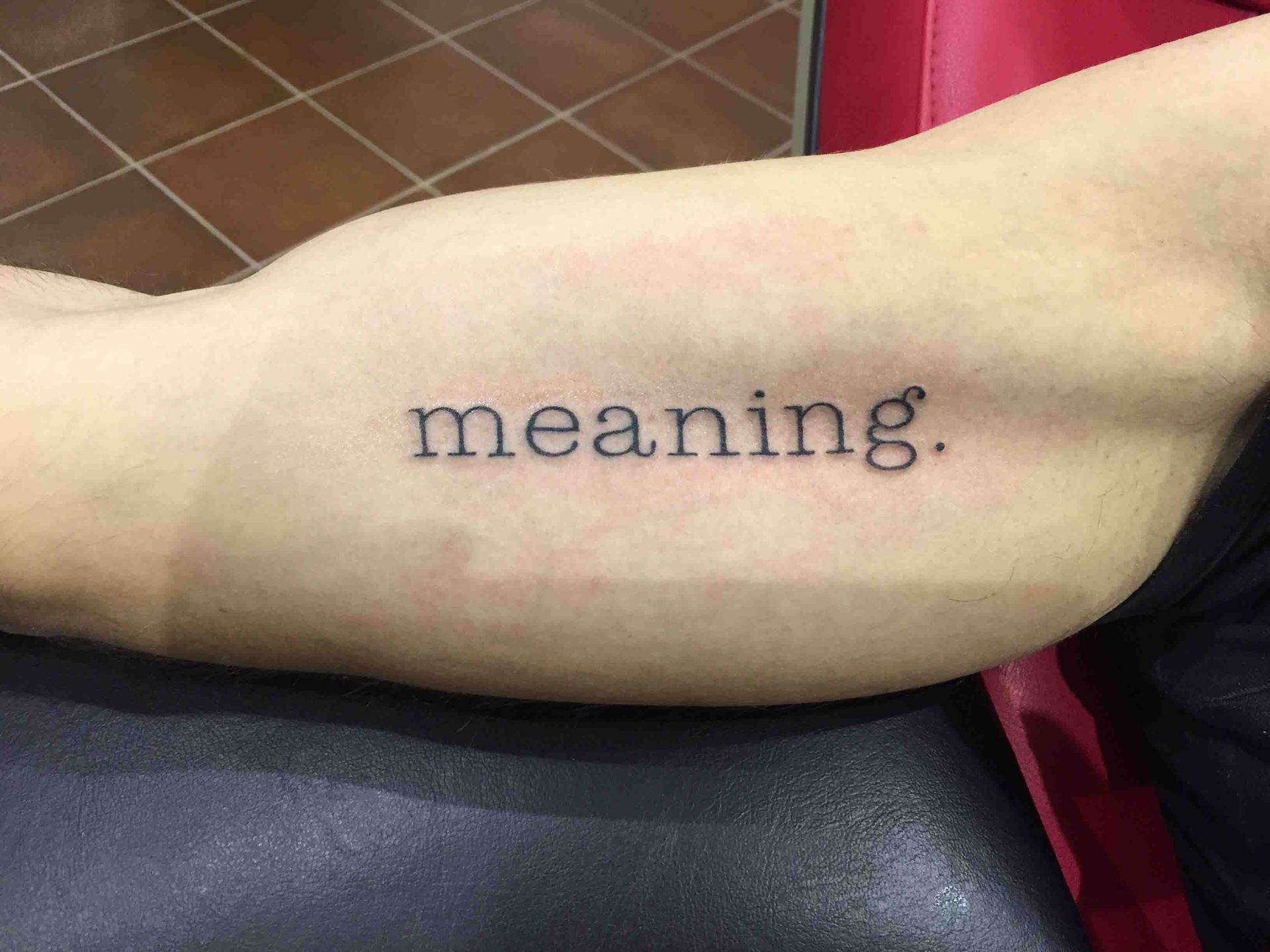 Het woord meaning op een onderarm