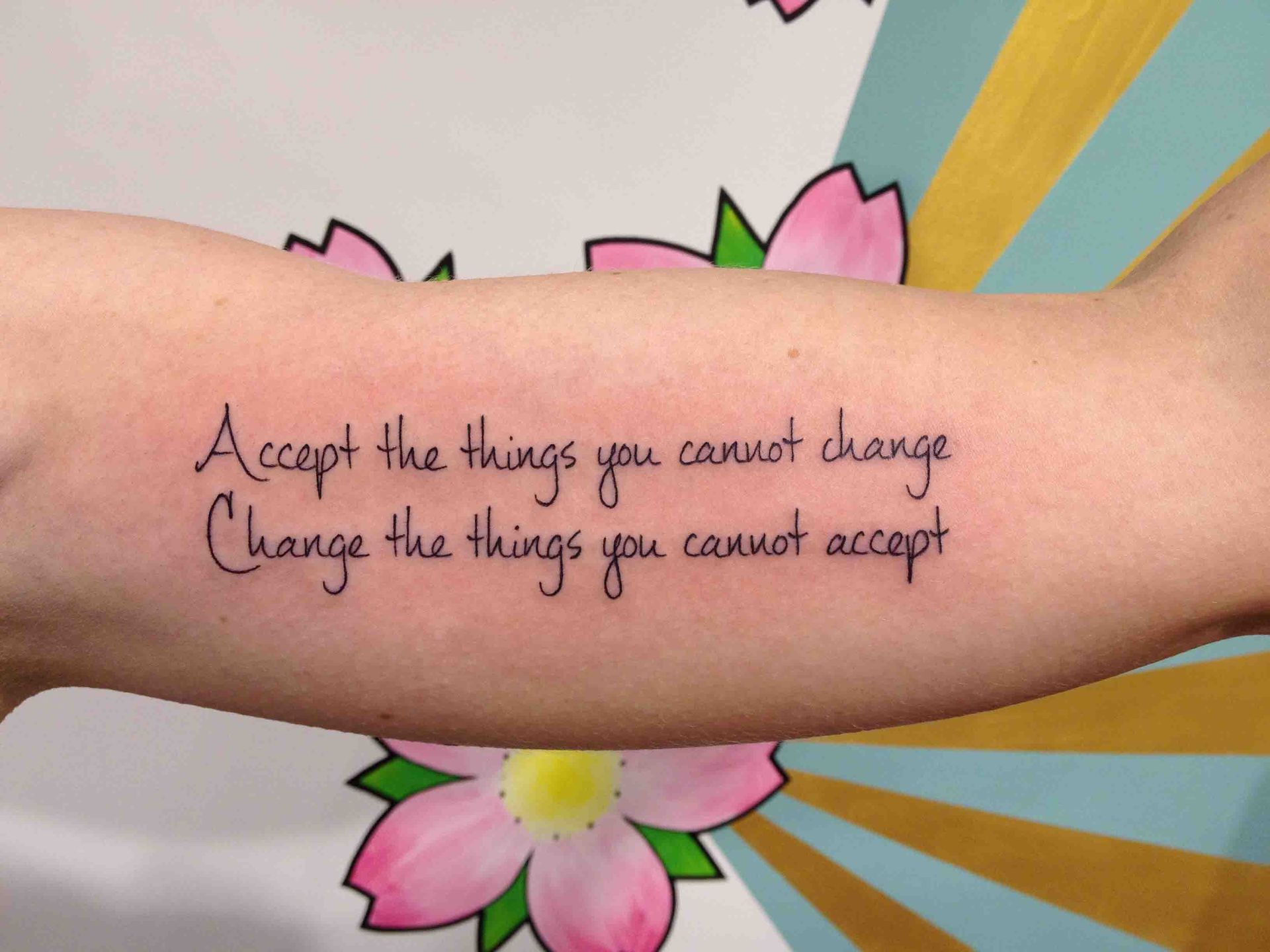 Tekst op een onderarm: Accept the things you cannot change, change the things you cannot accept