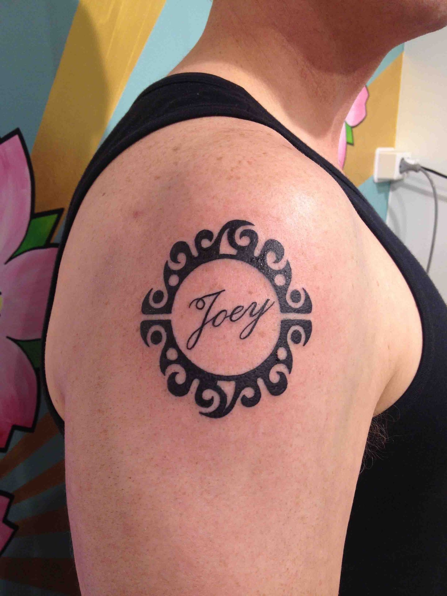De naam Joey in een sierlijke ronde tribal-lijst op een schouder