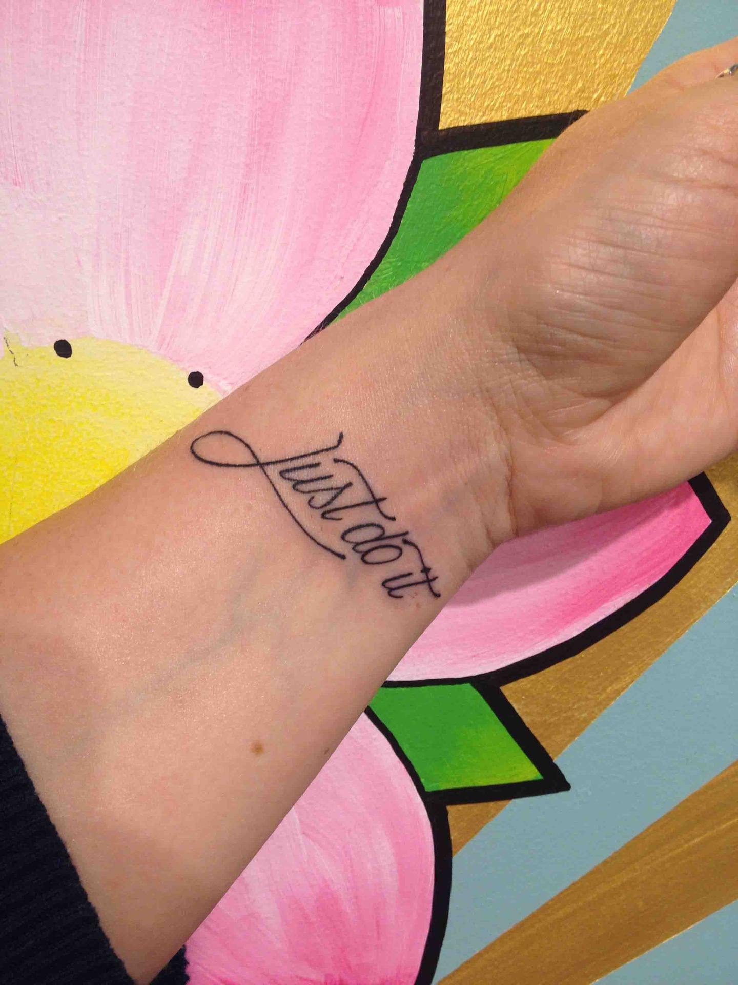 De woorden Just do it in sierletters op een pols
