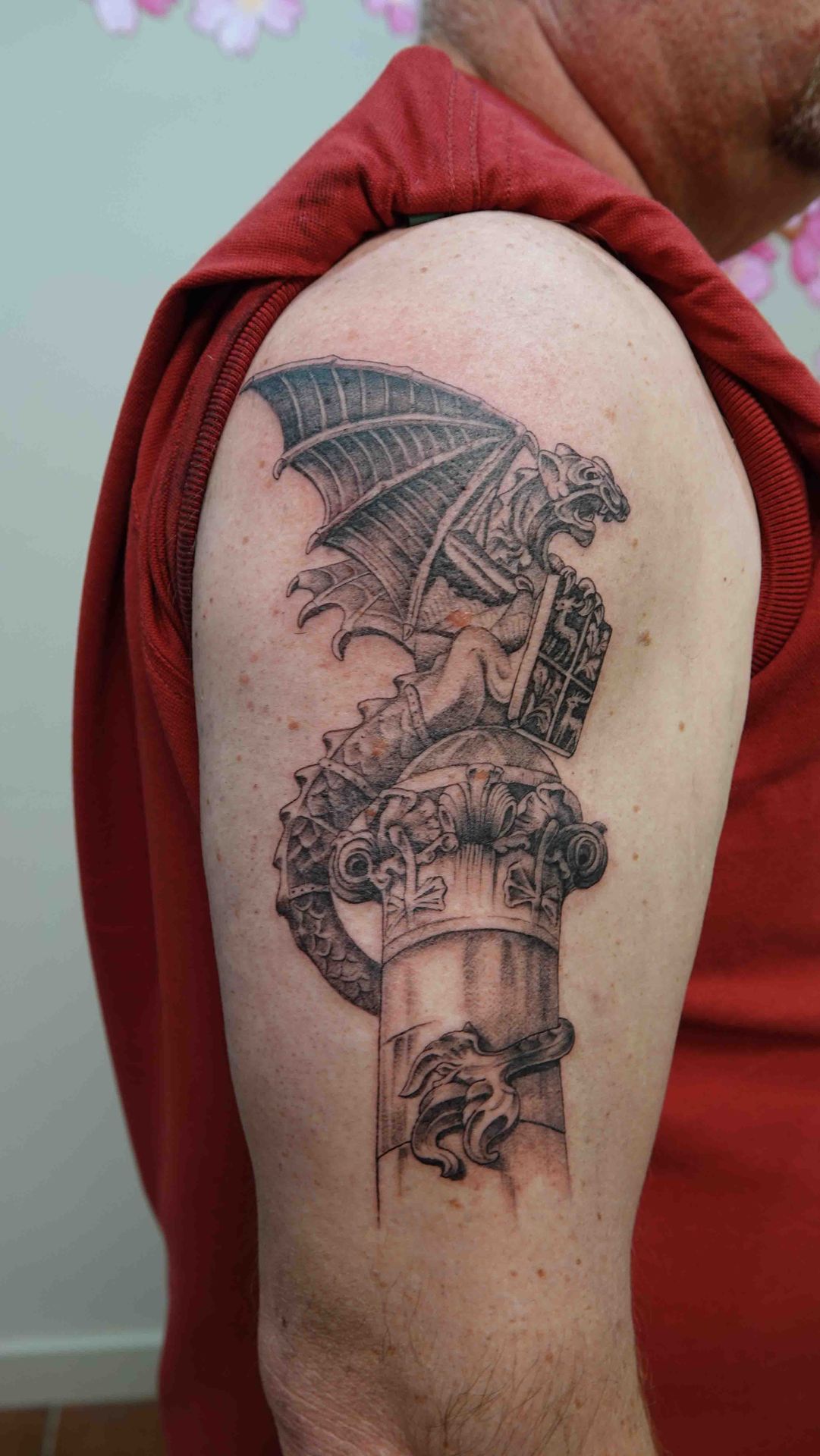 Gargouille op een stenen zuil, getatoeëerd op een bovenarm