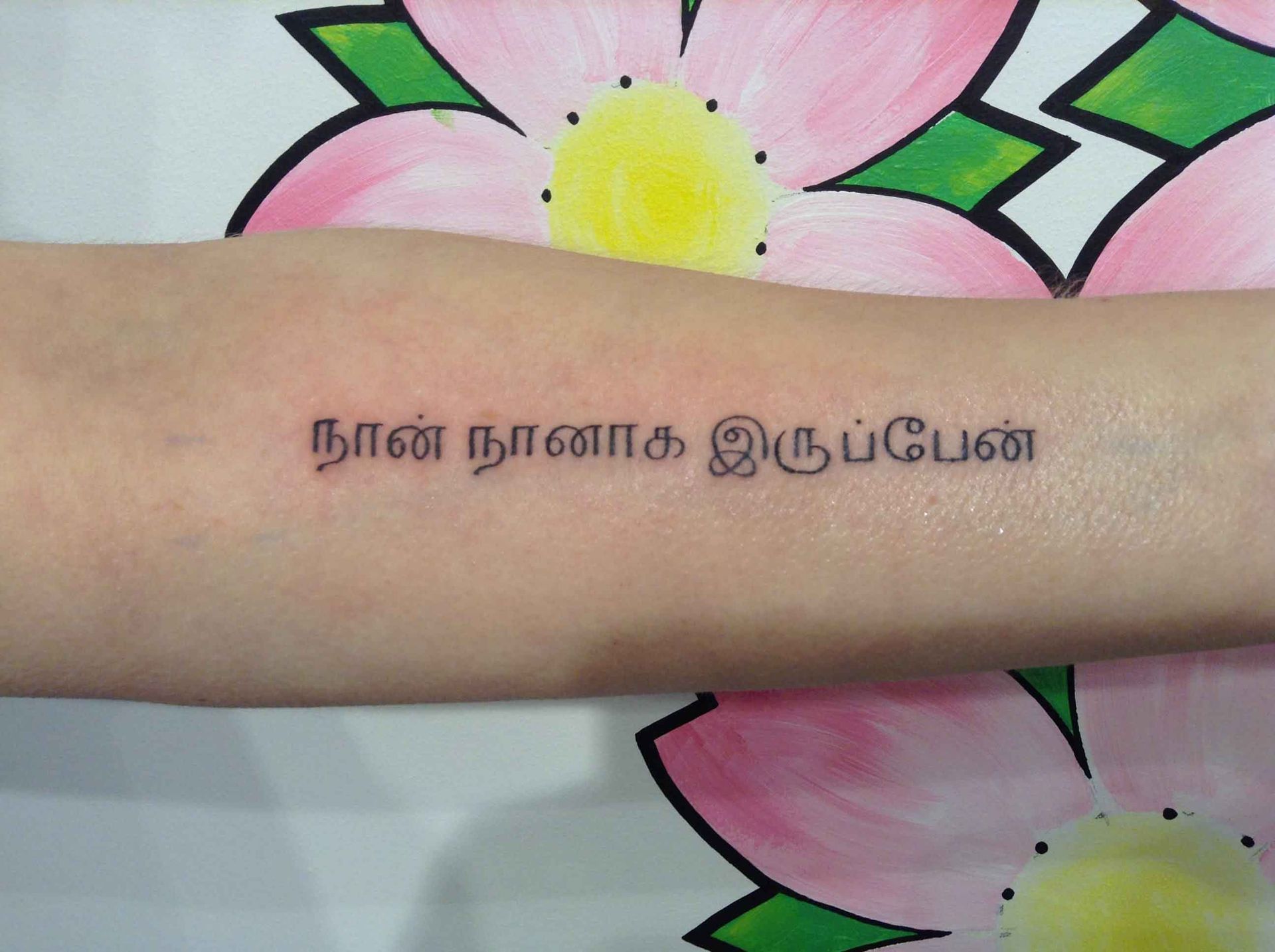 Tekst in Tamil-schrift op een onderarm